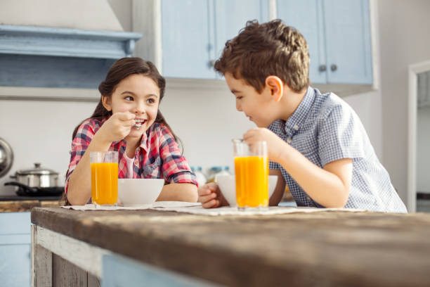 istock Delighted girl looking at her brother and eating 925071756