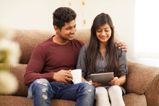 istock Cheerful young beautiful couple chatting with tablet and coffee 925083632