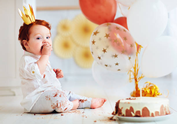 istock funny infant baby boy tasting his 1st birthday cake 925083876