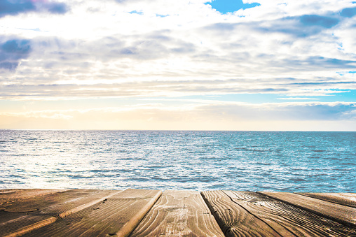 Wooden table top on blue sea and white sand beach