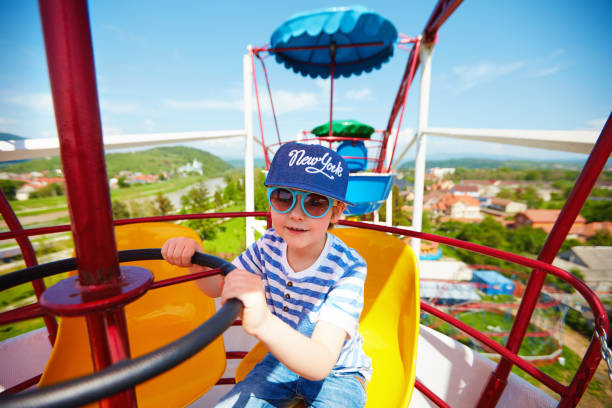istock excited kid riding on ferris wheel in amusement park 925084324
