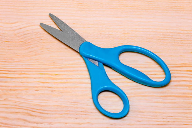istock Blue scissors. Object is isolated on wood background without shadows. 925084594