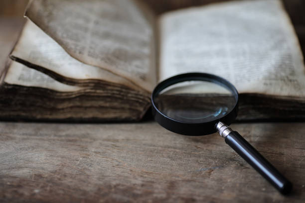 istock Old books on a wooden table and magnifier 925085070
