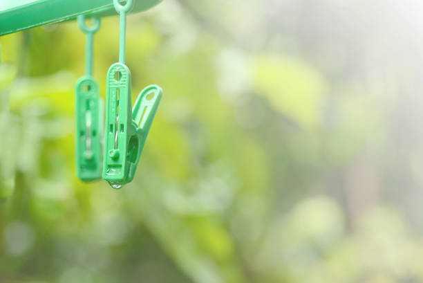 istock Green plastic clothespin clip with water drop. 925085240