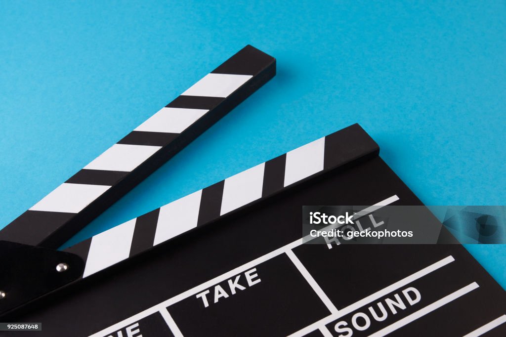 Movie clapper board on blue background Movie clapper board on blue background with copy space, close-up, view from above. Cinema and movie time concept Above Stock Photo
