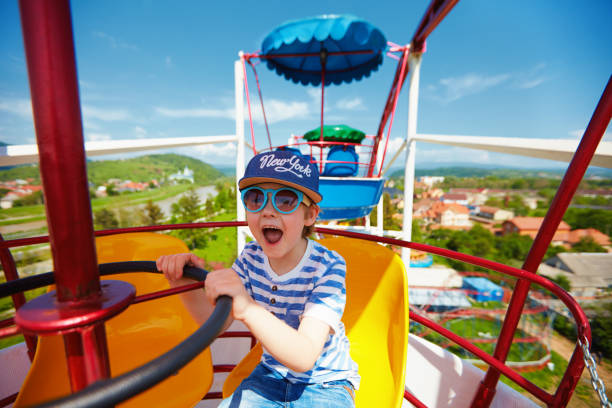 istock excited kid riding on ferris wheel in amusement park 925087732