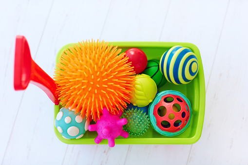 colorful toy trolley full of vibrant and various shape tactile balls for kid's development