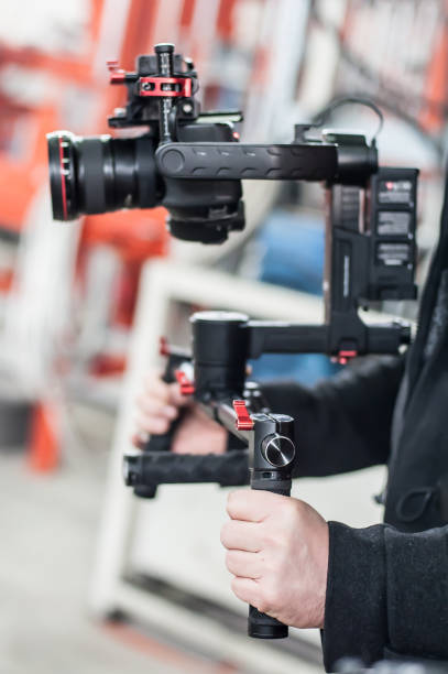 istock Videographer using stadicam, making video of machine at factory 925091414
