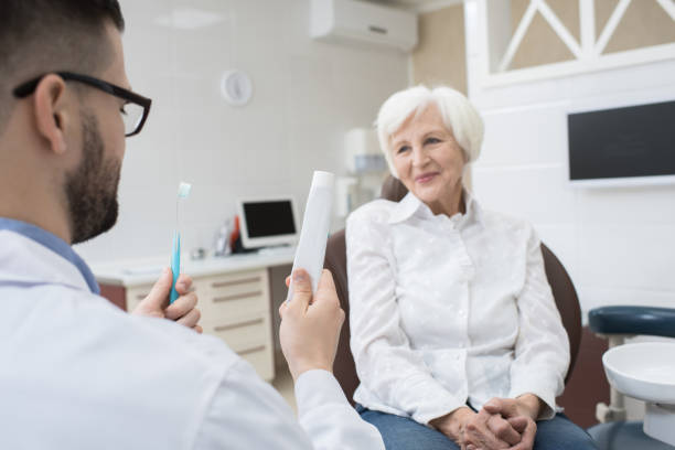istock Dental doctor showing toothbrush and toothpaste to patient 925099994