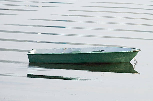 green row boat with ripples stock photo