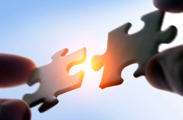 Putting puzzle pieces together stock photo