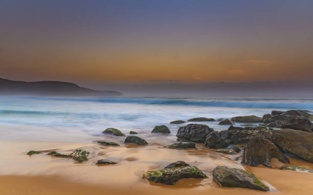 istock Hazy and Rocky Sunrise Seascape 925103400