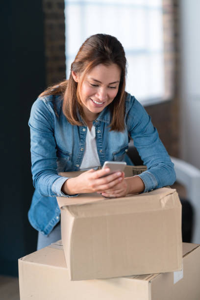 istock Happy woman social networking while moving house 925104604