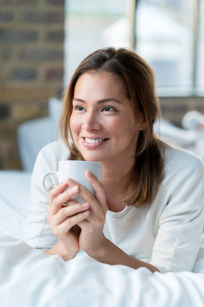 istock Thoughtful woman relaxing at home drinking coffee in bed 925104626