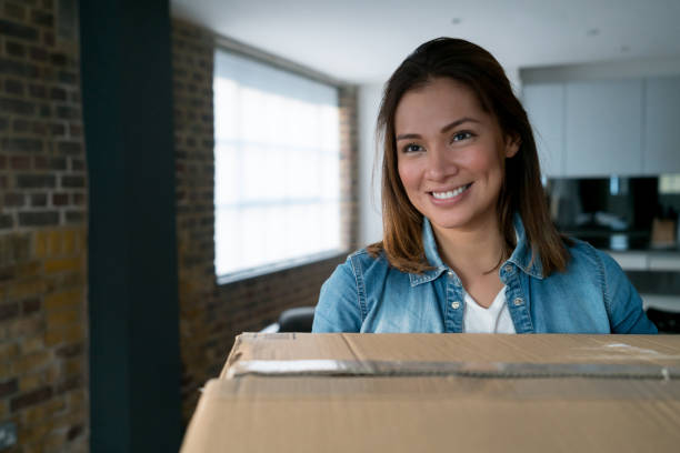 istock Happy woman moving house and packing in boxes 925104678