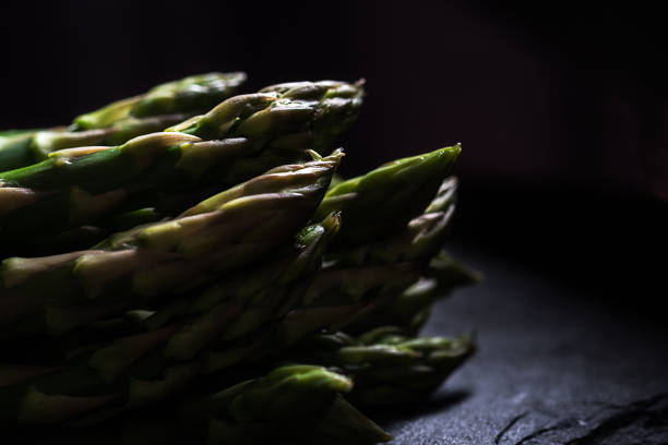 Close up on a bunch of green asparagus dark mood