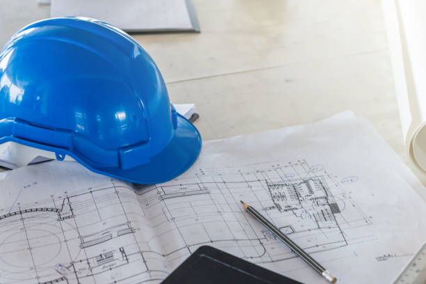 istock The blue safety helmet and the blueprint at construction site 925110988