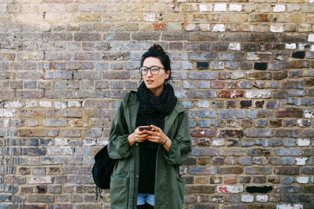 istock Young brunette texting on the cellphone in London downtown 925122664