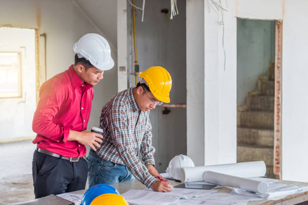 retrato del ingeniero verificar el plan de acción en la mesa y hablar sobre el proyecto de construcción con compromiso con el éxito en el sitio de construcción - manual worker portrait helmet technology fotografías e imágenes de stock