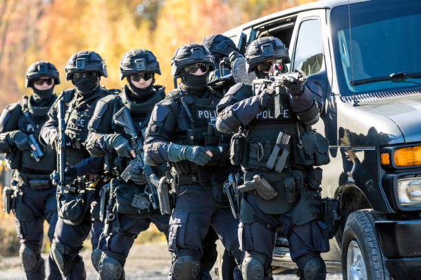 Police Swat Team at Work Police Swat Team at Work Going out of the vehicle and moving forward the danger. special forces photos stock pictures, royalty-free photos & images