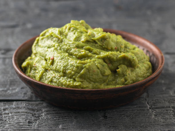 istock Freshly made guacamole in a clay bowl on a dark rustic table. Raw food. 925126926