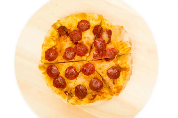 Top view of pepperoni pizza on wooden plate