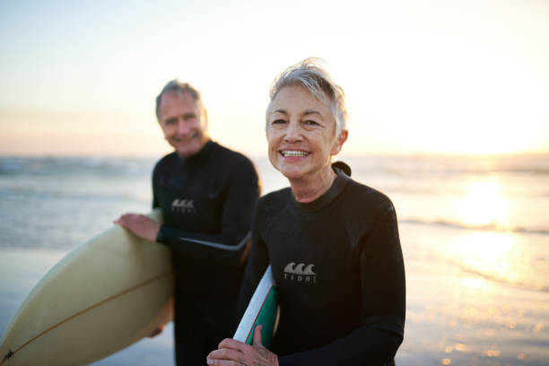 The perfect way to spend their free time Cropped shot of a senior married couple coming from surfing beach lifestyle stock pictures, royalty-free photos & images