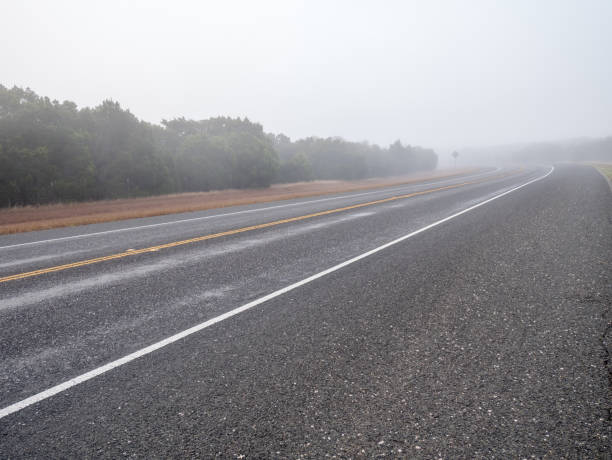 einzelne lane straße biegen links in dichtem nebel in der tageszeit - no passing lane stock-fotos und bilder