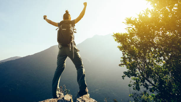 istock successful hiker with arms outstretched on sunrise mountain top 925147970