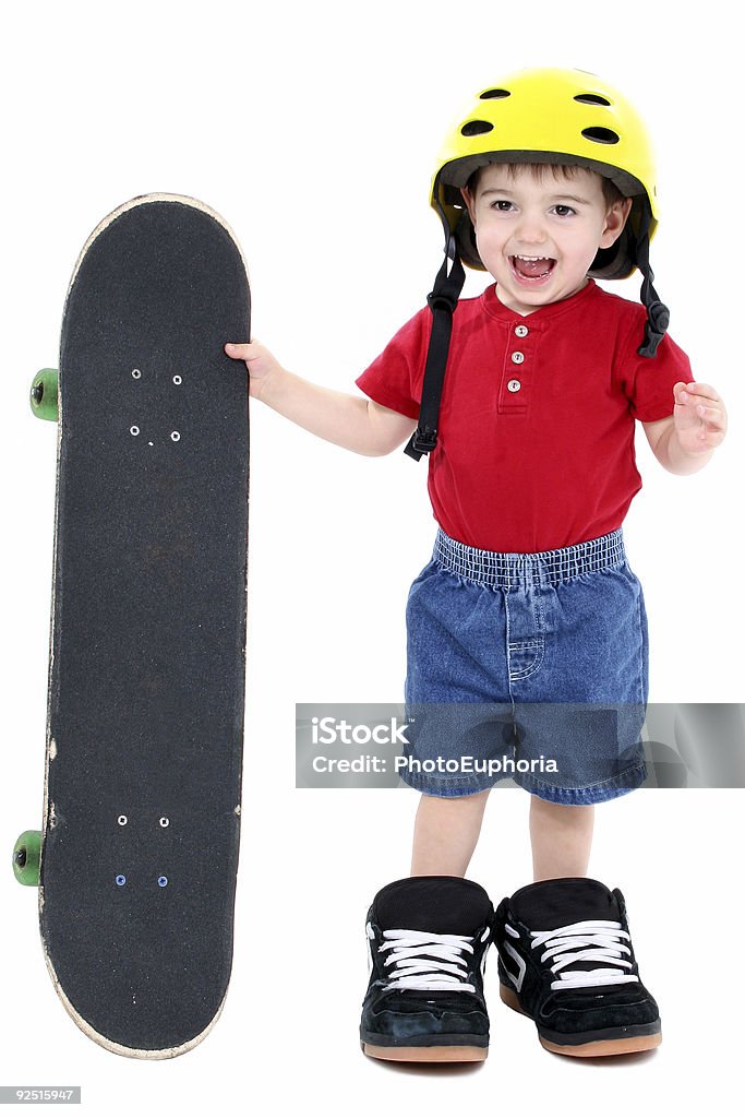 Boy In Large Shoes With Helmet And Skateboard Over White  Boarding Stock Photo