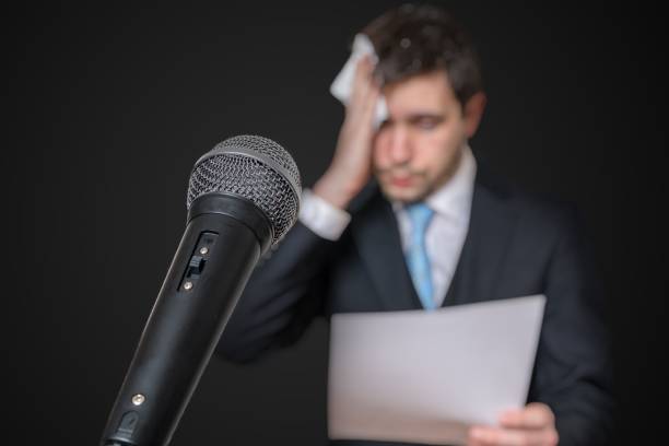 Microphone in front of a nervous man who is afraid of public speech and sweating. Microphone in front of a nervous man who is afraid of public speech and sweating. public speaker photos stock pictures, royalty-free photos & images