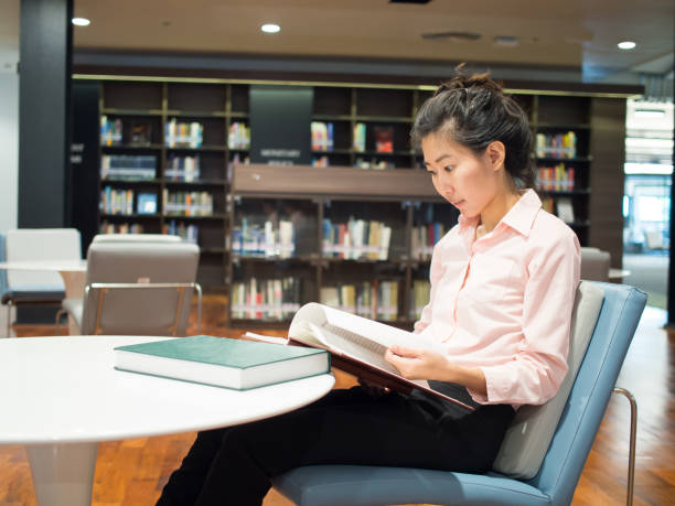 istock An asian female is reading books, study and research for her work. 925159712