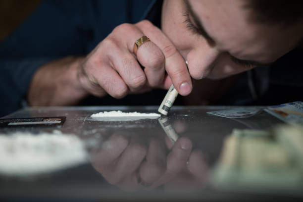 istock Addict man smells cocaine from a mirror 925160374