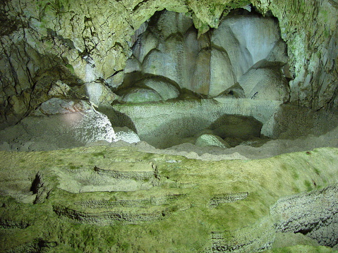 A wild cave inside. Stalactites and stalagmites. Speleology and surveys