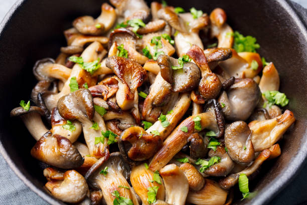 튀긴 검은 무 쇠 냄비에 신선한 약초와 버섯. - edible mushroom 뉴스 사진 이미지