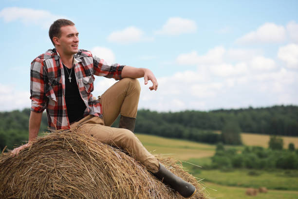 istock Young man in boots in village field at sunset 925170322