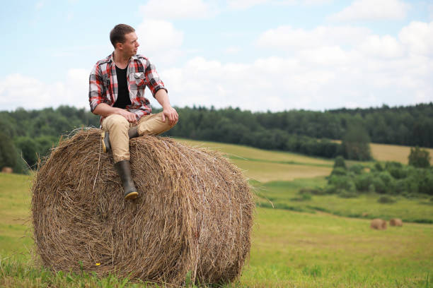 istock Young man in boots in village field at sunset 925170384