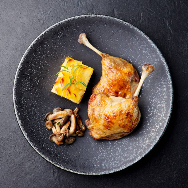 istock Duck legs confit with potato gratin and mushroom sauce. Restaurant serving. 925170434