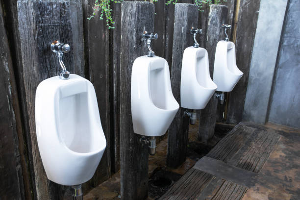 fond de toilettes hommes urinoirs - urinal public restroom male toilet in a row photos et images de collection