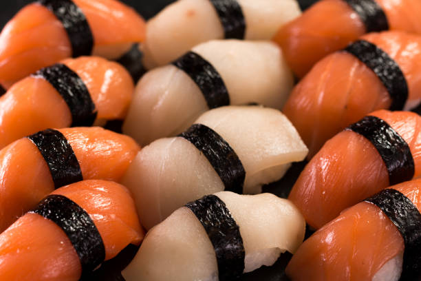 Various kinds of sushi served on a platter with soy sauce, wasabi and pickled ginger.