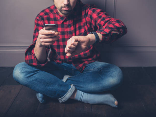 istock Young man on wooden floor with smart watch 925172890