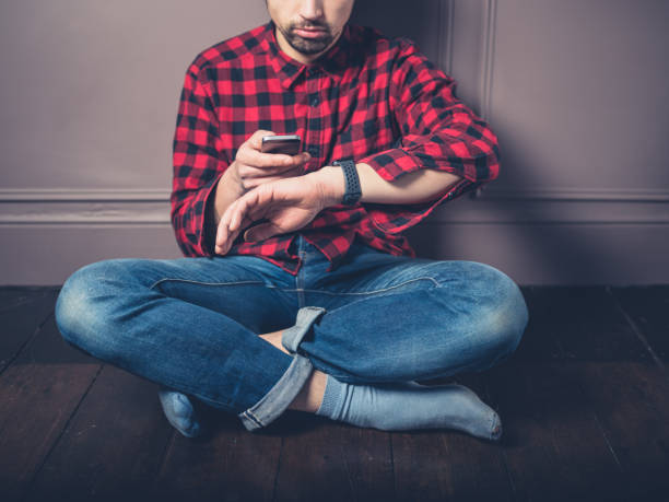 istock Young man on wooden floor with smart watch 925172962