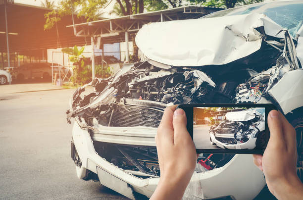 un hombre fotografió a su vehículo con daños accidentales con un teléfono inteligente. concepto de seguros de coche - accidente de automóvil fotos fotografías e imágenes de stock