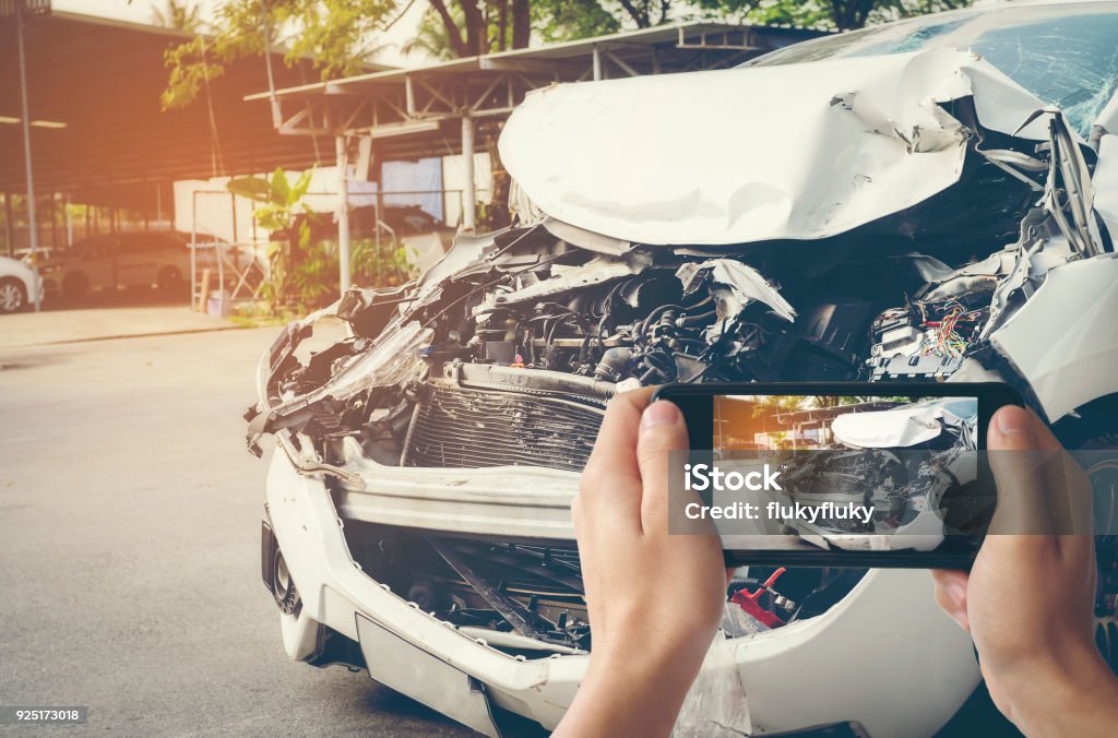 A man photographed his vehicle with accidental damage with a smart phone.Car Insurance Concept Car Accident Stock Photo