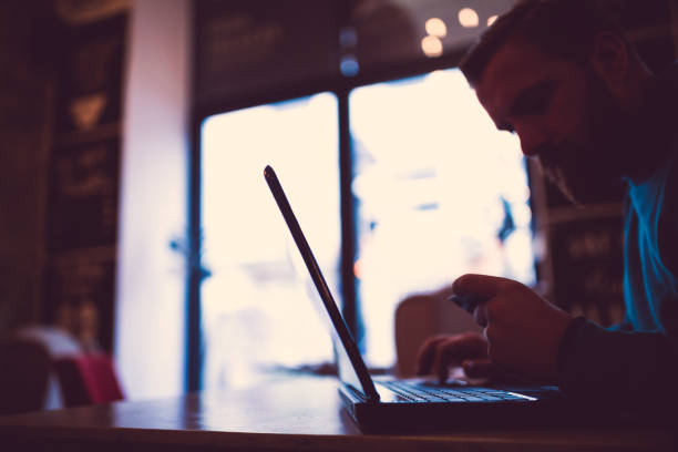 istock Young, redhead businessman, on coffee break browsing internet, making oline purchase with credit card. He is sitting in cafe 925175640
