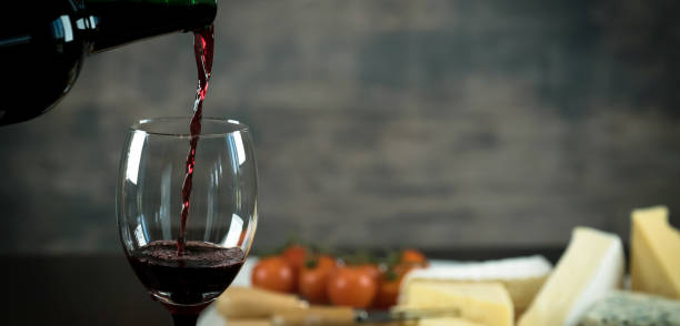 istock Red wine poured into a glass with cheese board 925176320