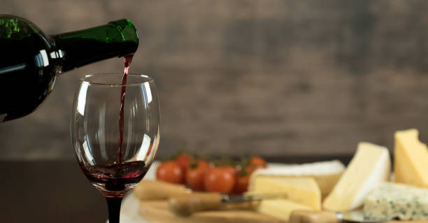 istock Red wine poured into a glass with cheese board 925176322
