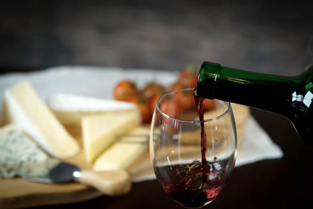 istock Red wine poured into a glass with cheese board 925176356