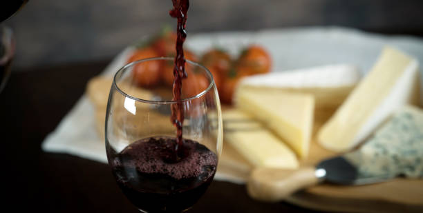 istock Red wine poured into a glass with cheese board 925176358