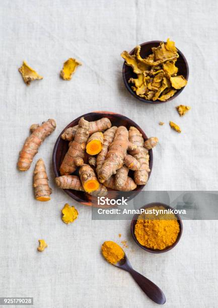 Fresh And Dried Turmeric Roots In A Wooden Bowl Grey Textile Background Top View Stock Photo - Download Image Now